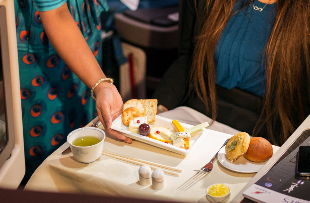 An air hostess serving a meal to a passenger