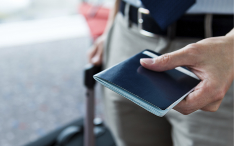 A man checking the phone while holding onto a travelling bag
